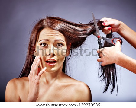 Woman at hairdresser with iron hair curler.