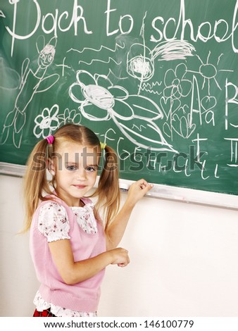 School girl writing on black board. Education.