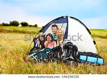 Group people with big backpack in tent summer outdoor.
