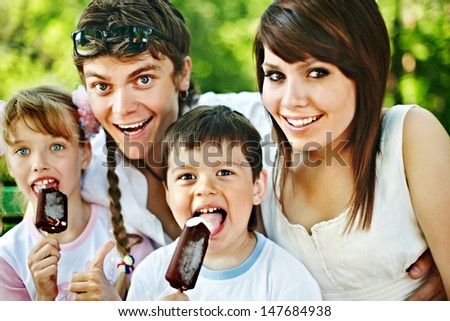 Happy family and group children eat ice cream. Outdoor.