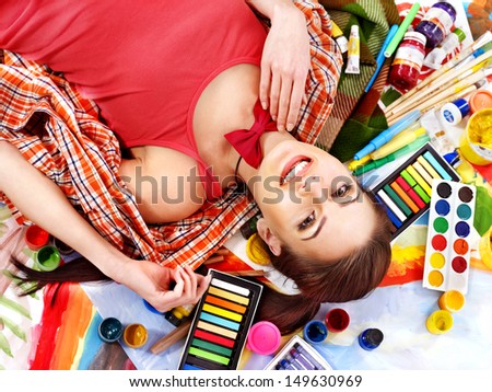 Artist woman lying on paint palette.