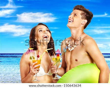 Couple with cocktail at Hawaii wreath beach. Summer outdoor.