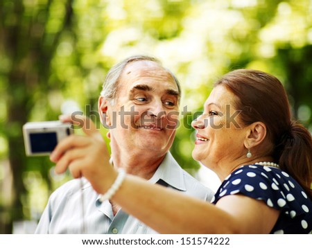 Happy old couple with camera take pictures.