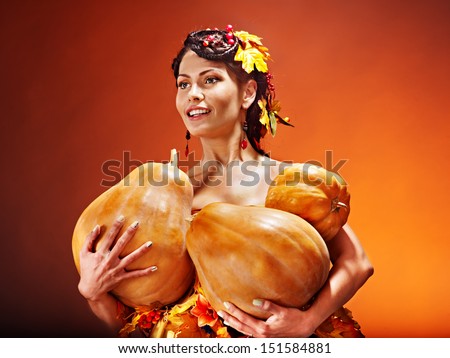 Woman holding autumn pumpkin and leaves.