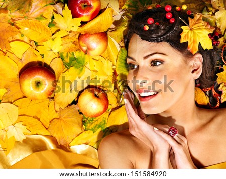 Woman holding autumn apple and leaves.