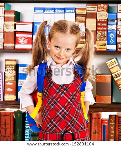 Child with backpack take book in library.