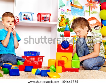 Little boy  in kindergarten stacking block.