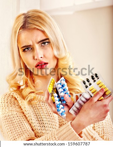 Young woman having flu takes pills.