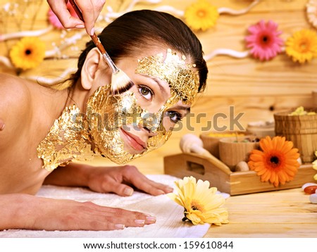 Woman getting  gold facial mask.