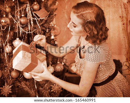 Woman receiving gifts under Christmas tree. Black and white retro.