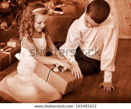Children  receiving gifts under Christmas tree. Black and white retro.
