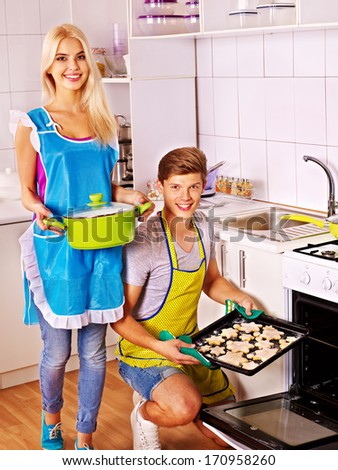 Happy family baking cookies in oven.