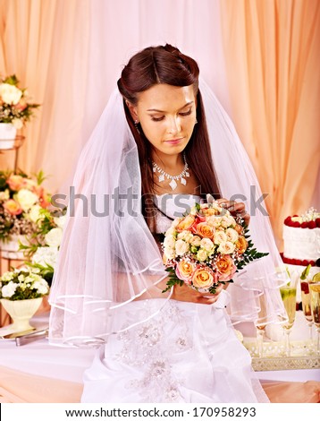 Sad bride at wedding table and cake.