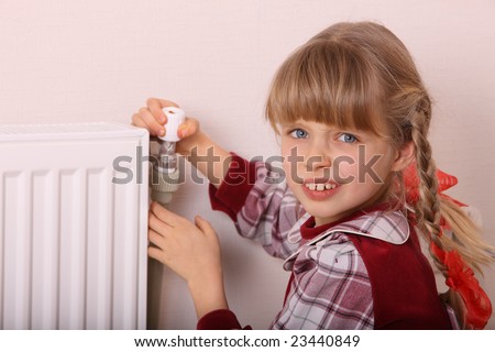 Girl try open thermostat. Energy crisis.
