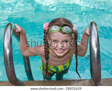 Girl in protective goggles leaves pool.