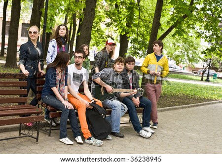 Group of people on bench in park. Outdoor.