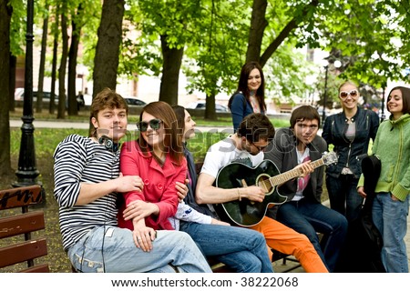 Group of people in city park listen music.Outdoor.