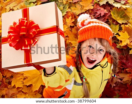 Girl in autumn orange  hat on leaf and gift box.Outdoor.