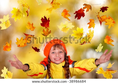 Girl child in autumn orange hat with outstretched arm.  Outdoor.