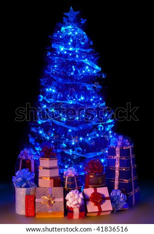 Christmas tree with light and group gift box. Black background.