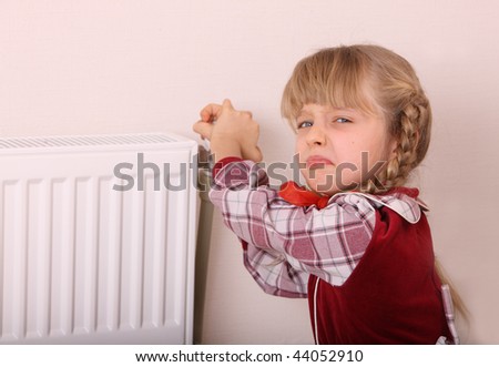 Girl try open thermostat. Energy crisis.