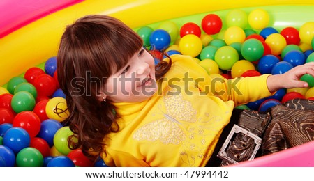Preschooler girl with ball in play room. Childcare.