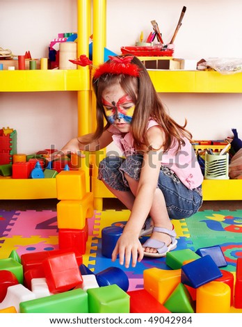 Child with puzzle, block and construction set in play room. Preschool