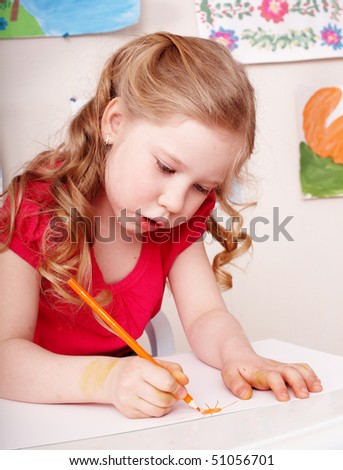 Little girl with colour pencil draw in preschool.