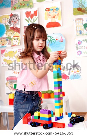 Child preschooler play construction set  in play room.