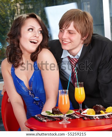 Loving couple eating cake in restaurant.