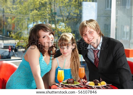 Happy family with child in cafe.