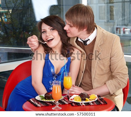People eating cake in restaurant. Loving couple.