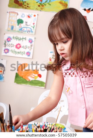 Child preschooler with pencil in play room.