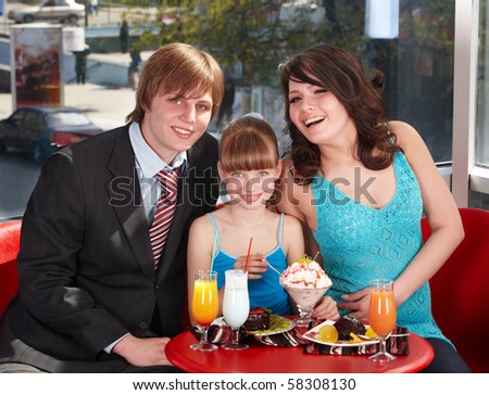 Happy family with child in restaurant.