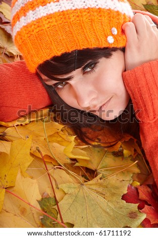 Girl in orange hat on leaves with sad face. Autumn depression.