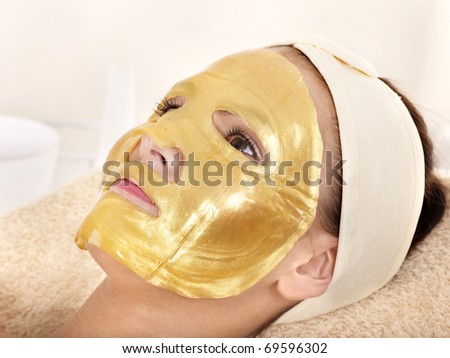 Young woman with gold facial mask.