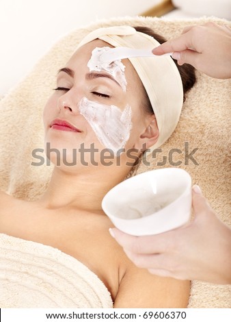 Beautician applying  facial mask by young woman.