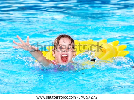Child on inflatable ring in swimming pool.