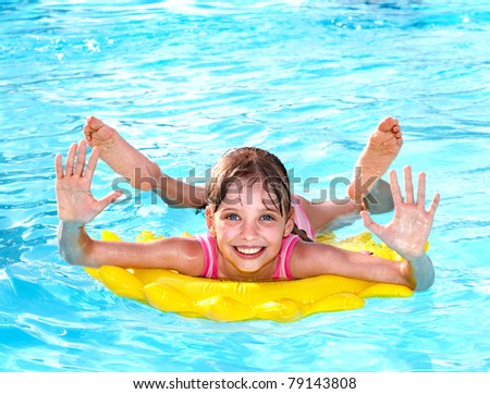Children  on inflatable ring in swimming pool.