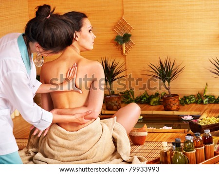 Young woman getting massage in bamboo spa.. Young woman getting massage in bamboo spa..