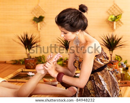 Young woman getting foot massage in bamboo spa.