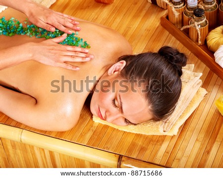 Young woman getting salt massage.