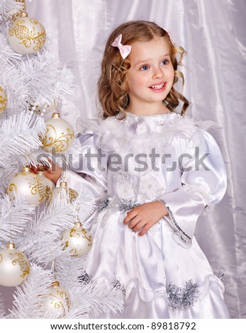 Child holding gift box and decorate white Christmas tree.