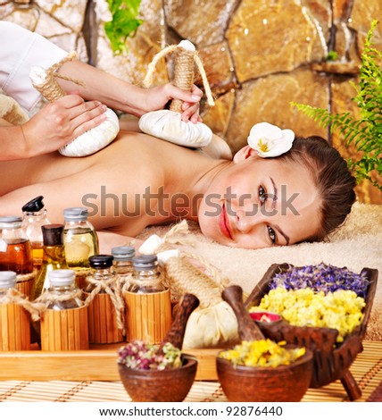 Woman getting thai herbal compress massage in spa.
