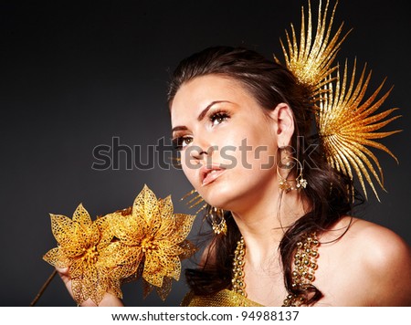 Beautiful young woman  in carnival costume with gold flower.