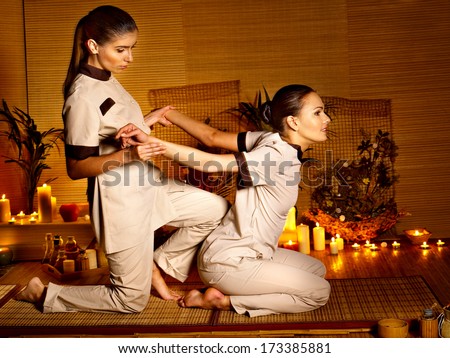 Therapist giving Thai stretching massage to woman.