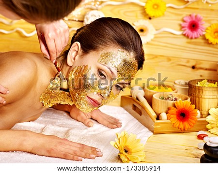 Woman getting  gold facial mask.
