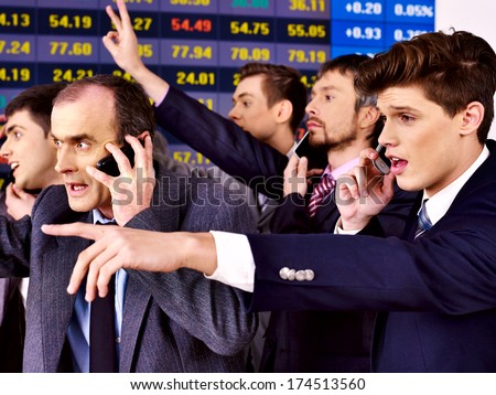 Group business people with  stock exchange board in office.