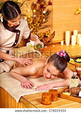 Young woman getting massage in bamboo spa.