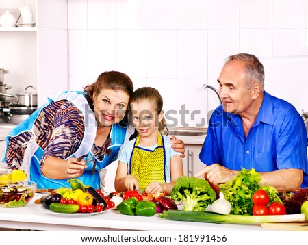 Family with child cooking at kitchen. Grandfather and grandmother.